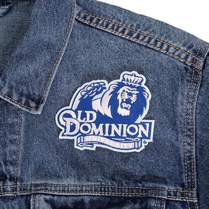 May include: A close-up of a blue denim jacket with a patch. The patch features a blue lion wearing a crown, with the words "Old Dominion University" in white and blue.