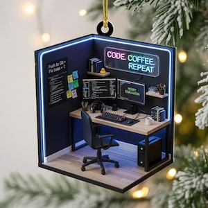 May include: A Christmas ornament shaped like a miniature office, featuring a desk with two computer monitors, a keyboard, and a chair. The text "CODE. COFFEE. REPEAT" is displayed above the desk. The ornament has a black and blue color scheme.