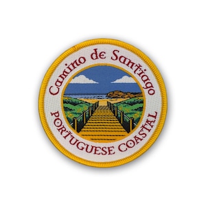 May include: Embroidered patch with the text "Camino de Santiago Portuguese Coastal" in a circular design. The patch features a coastal scene with a wooden walkway leading to the ocean, under a blue sky with clouds. The border is yellow.