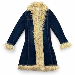 May include: A long, dark blue denim coat with faux fur trim. The coat has a light tan faux fur collar, cuffs, and a vertical trim down the front. It features long sleeves and a flared bottom.