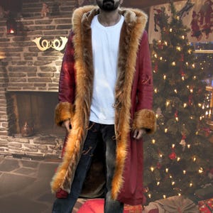 men red leather hooded coat, genuine sheepskin leather outerwear, faux shearling lining jacket, long vintage 80s coat, unisex winter fashion piece, front view hood up style, soft faux fur cuffs detail, bold red statement coat, casual streetwear styling, cold weather winter outfit, relaxed fit long coat, boho inspired outerwear, retro vintage jacket design, cozy warm winter wear, fashion forward unisex coat, red sheepskin leather coat for men, hooded winter jacket with synthetic fur interior,