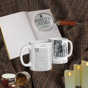 May include: An open book with a magnifying glass that reads "Sherlock Holmes" sits next to two white mugs with text and illustrations. A pipe, tobacco, and candles complete the scene, set on a brown plaid fabric.