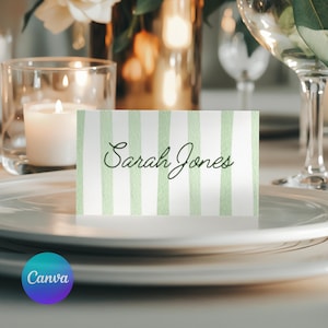 Op de afbeelding: Een naambordje met een groen en wit gestreept ontwerp. De naam "Sarah Jones" is in elegant schrift geschreven. De kaart staat op een wit bord, met een kaars en glaswerk op de achtergrond. Perfect voor bruiloften of evenementen.