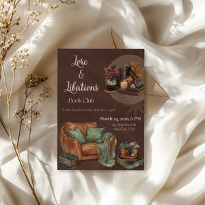 May include: A watercolor invitation for a book club called "Lore & Libations." The design features a brown background with illustrations of books, candles, and a cozy armchair. The text includes the book club name, the date, time, and location.