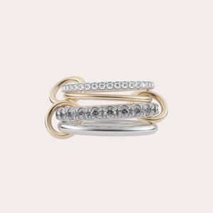 May include: A stack of four rings in gold and silver tones. Two rings are gold, one is silver, and one is gold with clear stones. The rings are linked together with gold connectors, creating a layered effect.