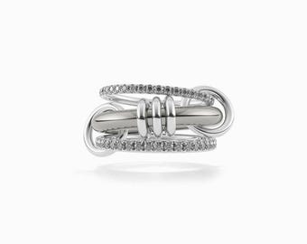 May include: A silver ring with a unique design. The ring features a central bar with three vertical cylinders, connected to two diamond-studded bands and two larger, circular elements. The ring is set against a white background.