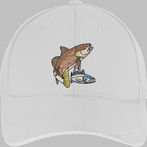 May include: White baseball cap featuring an embroidered design of two fish. The larger fish is brown and tan, with yellow fins. The smaller fish is blue and white. A classic, casual cap.