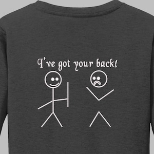 Può includere: Felpa grigio scuro con la scritta "I've got your back!" e illustrazioni di omini stilizzati. Un omino stilizzato ha un volto sorridente e tiene uno scudo, mentre l'altro ha un volto triste e le braccia tese.