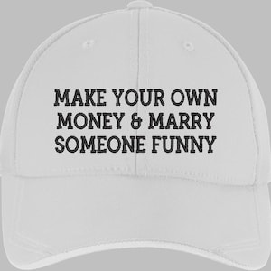 Può includere: Cappellino da baseball bianco con la scritta ricamata in nero "MAKE YOUR OWN MONEY & MARRY SOMEONE FUNNY". Il cappellino ha una visiera curva e un bottone sulla parte superiore. Realizzato in materiale morbido e resistente.