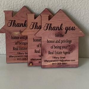 Puede incluir: Tres letreros de madera con forma de casa con el texto "Thank The Thank you for the honor and privilege of being your Real Estate Agent" y la informaci&oacute;n de contacto de Tiffany Snell.