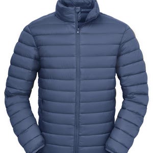 Puede incluir: Chaqueta acolchada azul con cuello alto y cremallera completa. La chaqueta tiene costuras horizontales acolchadas y mangas largas. La chaqueta es de color liso y parece estar hecha de un material ligero.