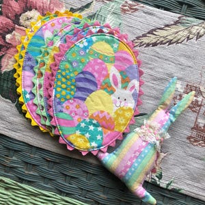 May include: A white ceramic mug with a black handle and the text "But First, Coffee" in a black, bold font. The mug is sitting on a wooden surface.