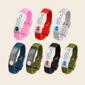 May include: Seven silicone medical alert bracelets in pink, red, light gray, blue, olive green, black, and dark green. Each features a metal plate with a Star of Life emblem and engraved text: Type 2 Diabetes, ICD MOM 123 456 7890, ICD DAD 123 456 7890.