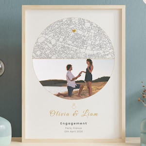May include: Framed engagement photo print featuring a map design and a couple. The print includes the names "Olivia & Liam", the word "Engagement", and the date "12th April 2026". The background is a light beige color.
