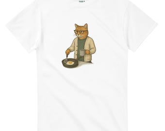 May include: White t-shirt featuring a cartoon cat wearing glasses and a cardigan, holding a mug and spatula while cooking an egg in a pan. The word "FABLE" is printed on the top of the shirt.