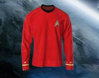 May include: Red long-sleeve shirt with a black V-neck collar and gold accents on the cuffs. A gold and yellow Starfleet insignia is on the left chest. The shirt is a costume or cosplay item.