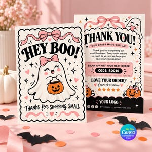 以下が含まれることがあります： ハロウィーンをテーマにした2枚の長方形のサンキューカード。手前のカードには、ピンクのリボンをつけた白いお化けがオレンジ色のカボチャのバケツを持っているイラストと、「HEY BOO!」「THANKS FOR SHOPPING SMALL」という文字が描かれています。後ろのカードには「THANK YOU」と書かれています。