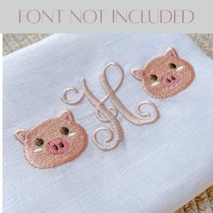 May include: White fabric with embroidered details. Features a large, cursive letter "H" in a light pink thread, flanked by two embroidered pig faces. The pig faces are light pink with dark brown eyes and pink snouts. The text "FONT NOT INCLUDED" is at the top.