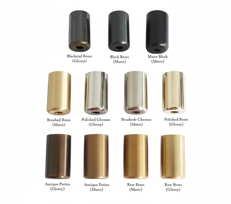 May include: A collection of twelve cylindrical metal hardware knobs arranged in three rows. The finishes include Blackened Brass, Black Brass, Matte Black, Brushed Brass, Polished Chrome, Brushed Chrome, Polished Brass, Antique Patina, and Raw Brass.
