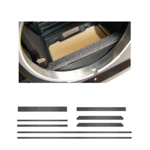 Op de afbeelding: Een close-up van een camera-interieur met een grijze schuimrubberen lichtafdichting en een set vervangende lichtafdichtingen. De camerabody is zilver en zwart. De vervangende afdichtingen zijn zwart en in verschillende vormen en maten.