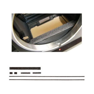 Op de afbeelding: Close-up van de binnenkant van een camera, met een zwarte schuimrubberen lichtafdichting en een zilveren metalen frame. Extra zwarte schuimstrips worden hieronder weergegeven. Camera reparatie onderdelen.