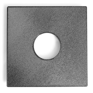 May include: A square, dark gray object with a circular hole in the center. The surface has a textured pattern. The object is set against a white background.