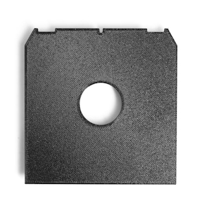 May include: A square, black, textured component with a circular aperture in the centre. The object features a diagonal pattern and a notched top edge. It is likely a part of a larger product or assembly.