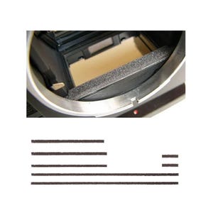 May include: Close-up of a camera interior with a black foam light seal and a silver metal frame. The image also shows several black foam strips, likely for light sealing or cushioning.