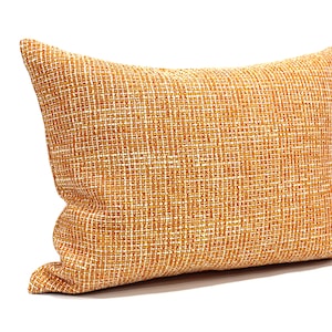 May include: A rectangular orange and white throw pillow with a textured woven fabric.