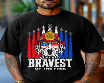 May include: A black t-shirt featuring a graphic of a Dalmatian dog wearing a red firefighter helmet and American flag sunglasses. Above the dog are helicopters with red and blue smoke trails. The text reads BRAVEST OF THE FREE.