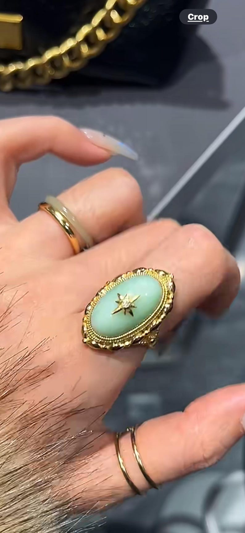 K&ouml;nnte beinhalten: Goldener Ring mit einem hellgr&uuml;nen, ovalen Stein und einem Sternmuster. Der Ring hat einen detaillierten goldenen Filigranrand. Ein zweiter goldener Ring mit einem hellgr&uuml;nen Band ist ebenfalls sichtbar.