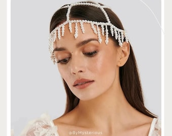 May include: A delicate, white pearl headpiece with a geometric design. The headpiece features a series of connected pearl strands that form a crown shape, with dangling pearl strands. The design is elegant and suitable for special occasions.