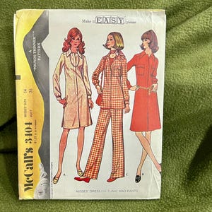 Può includere: Modello di cucito vintage McCall's per un abito o una tunica e pantaloni. Il modello è per le taglie 14 e 36, ed è etichettato come "Make it Easy". Il modello presenta tre donne che indossano diverse versioni del capo, una con un abito rosso, una con un abito bianco e una con una tunica e pantaloni a quadri.