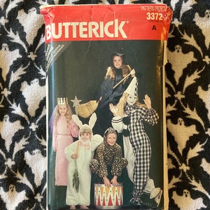 Può includere: Un modello di cucito vintage di Butterick, numero 3372, per realizzare costumi di Halloween per bambini. Il modello include cinque costumi diversi: una strega, un clown, un coniglio, un angelo e un leone. Il modello è di taglia A.