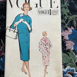 Pode incluir: Padrão de costura vintage Vogue para um casaco, tamanho 14, busto 86 cm, quadril 91 cm. O padrão apresenta duas ilustrações de mulheres vestindo casacos, um em azul turquesa sólido e o outro com estampa floral. O padrão é rotulado como "Vogue Special Design" e "Padrão Impresso".