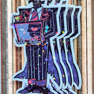 May include: A stack of stickers featuring a cartoon character with a television for a head, wearing a suit with star and stripe patterns. The stickers have a light blue outline and holographic accents.