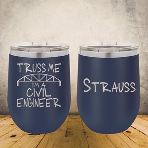 May include: Two navy blue stainless steel tumblers with clear lids. The left tumbler features a white graphic of a bridge with the text "TRUSS ME I'M A CIVIL ENGINEER". The right tumbler features the white text "STRAUSS" in a simple font.