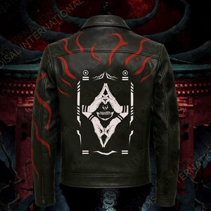 May include: Black leather jacket with red flame-like designs on the shoulders and back. The back features a white graphic of hands in a prayer position with a skull and geometric shapes. A classic collared jacket.