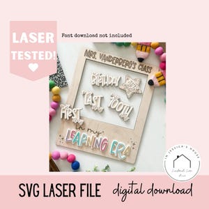 May include: A wooden frame with laser-cut words and phrases for a classroom or learning environment. Phrases include "Birthday," "Last Day," and "First Day." The frame also has the text "Mrs. Vanderberg's Class" and "Learning Era."