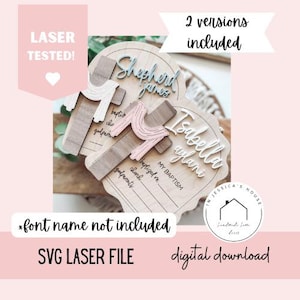 Puede incluir: Recuerdos de bautizo de madera con detalles de cruz. Uno presenta el nombre "Shepherd James" en azul, el otro "Isabella aylani" en blanco. La imagen incluye texto: "LASER TESTED!" y "2 versiones incluidas". Descarga digital.