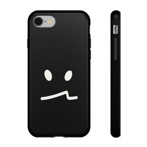 Puede incluir: Funda de teléfono negra con un diseño minimalista de cara. El diseño presenta dos ojos ovalados blancos y una boca curva blanca. La funda se muestra desde el frente y el lateral, destacando su diseño protector.
