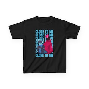 May include: Black t-shirt with a cartoon graphic of two characters and the text "CLOSE TO ME" in blue. One character is in blue, the other in red. The design is centrally placed on the shirt.