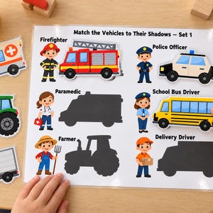 May include: A white educational activity board titled Match the Vehicles to Their Shadows – Set 1, featuring cartoon illustrations of a firefighter, police officer, paramedic, school bus driver, farmer, and delivery driver with corresponding vehicle cutouts.
