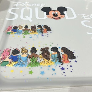 May include: A white ceramic mug with a black handle and the text "But First, Coffee" in a bold, black font. The mug is set against a neutral background, highlighting its simple design.