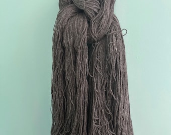 A Luxurious  Suri llama / Finnsheep yarn, worsted weight. Natural, dark gray color, three ply yarn with luster.
