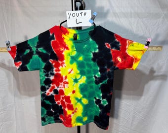 T-shirt tie-dye fatta a mano. 100% cotone, taglia L da ragazzo. Piegatura glitch nei colori rasta.