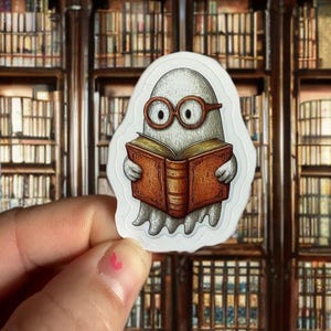 May include: A white sticker featuring a cartoon ghost wearing round glasses and reading a brown book. The ghost has a friendly expression. The background is a blurred image of a library.
