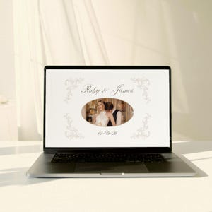 May include: A laptop displays a wedding photo album. The screen shows a photo of a couple in an oval frame, with the names "Ruby & James" above and the date "12-09-26" below. Floral designs frame the text.