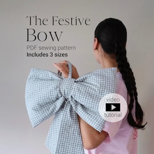 May include: A large, light blue and white gingham bow held by a person. The text "The Festive Bow" is at the top, with "PDF sewing pattern" and "Includes 3 sizes" below. A video tutorial icon is also present.
