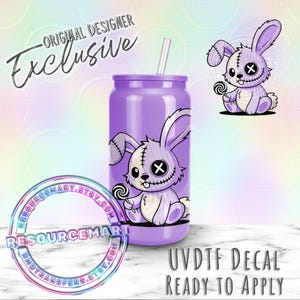 May include: A purple tumbler with a cartoon bunny design holding a lollipop. The bunny has stitched details and an X for an eye. The text "Original Designer Exclusive" and "UVDTF DECAL READY TO APPLY" are also visible.